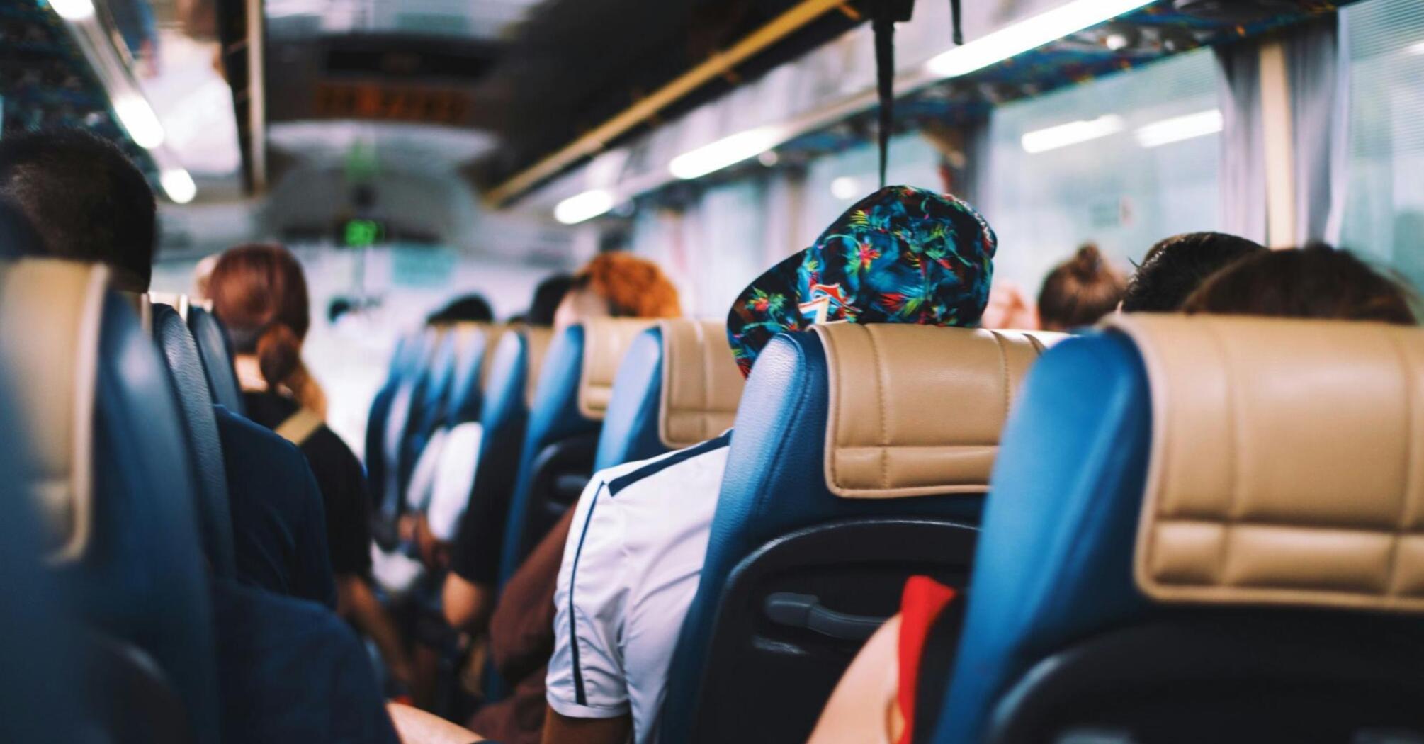 People seated in a bus, view from behind