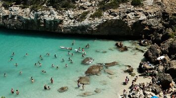 Crowded beach in Mallorca with tourists swimming and sunbathing