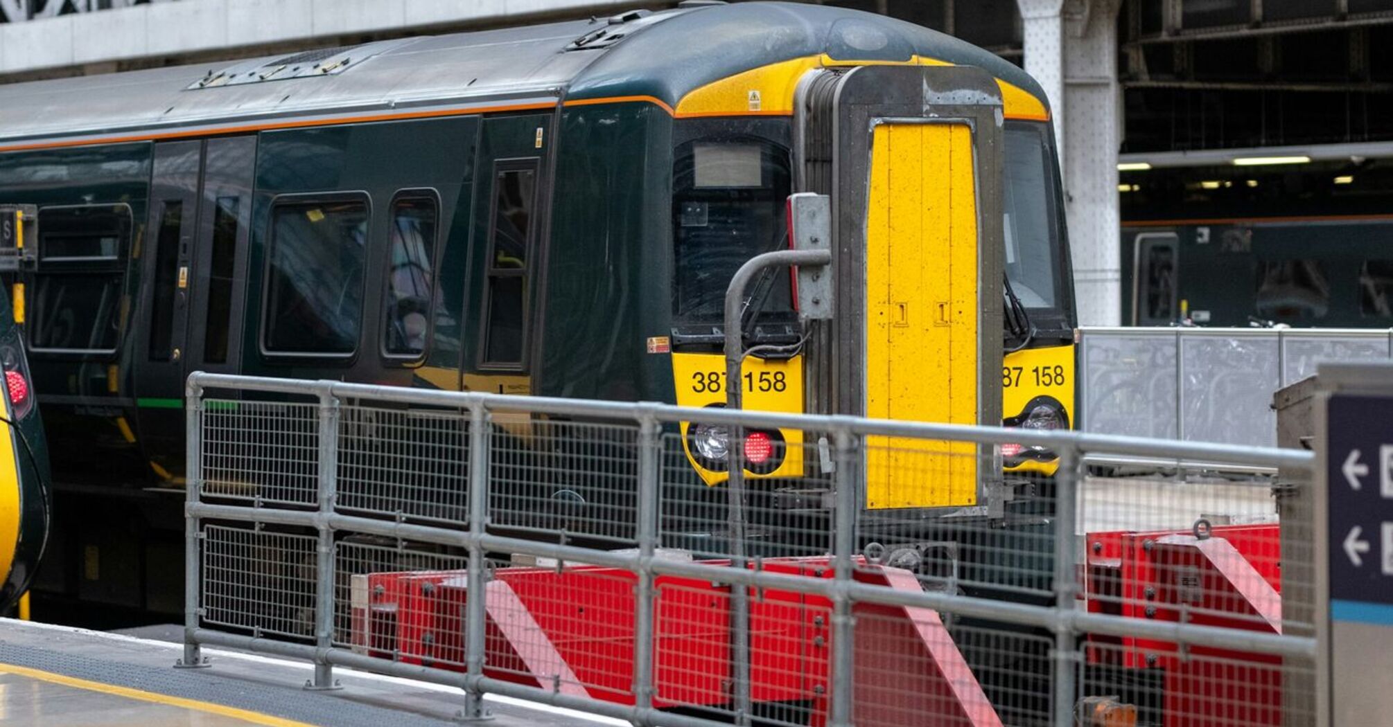 A stationary GWR train at a platform inside a London Paddington station, ready for passenger boarding