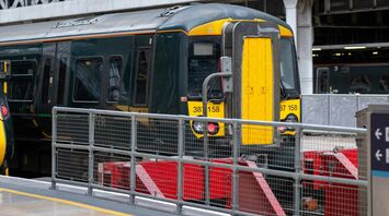 A stationary GWR train at a platform inside a London Paddington station, ready for passenger boarding