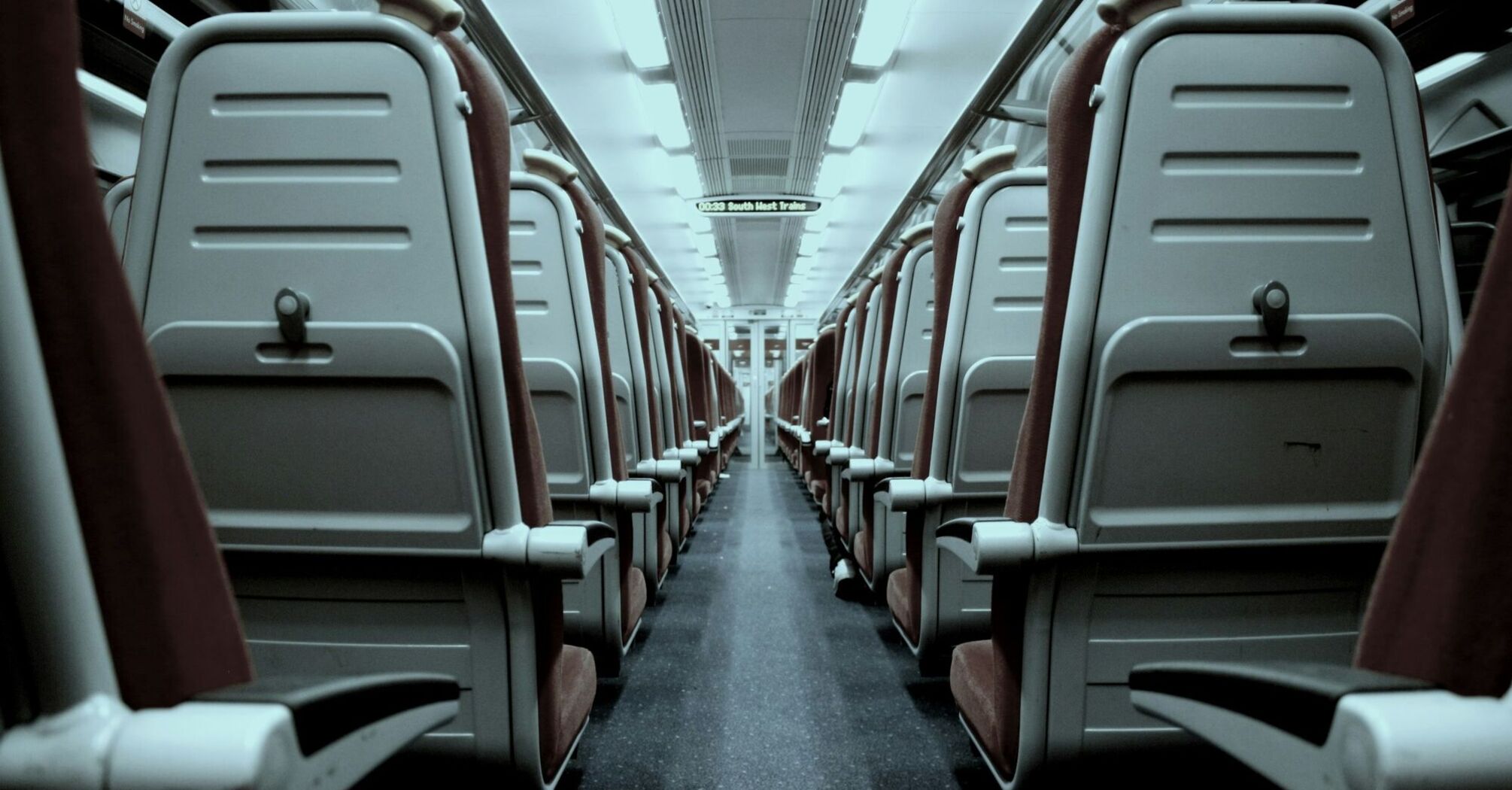 Interior of an empty train carriage with rows of seats