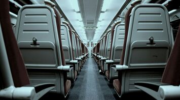 Interior of an empty train carriage with rows of seats