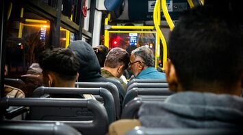 A diverse group of passengers sitting inside a bus during a night journey, highlighting a casual and comfortable atmosphere