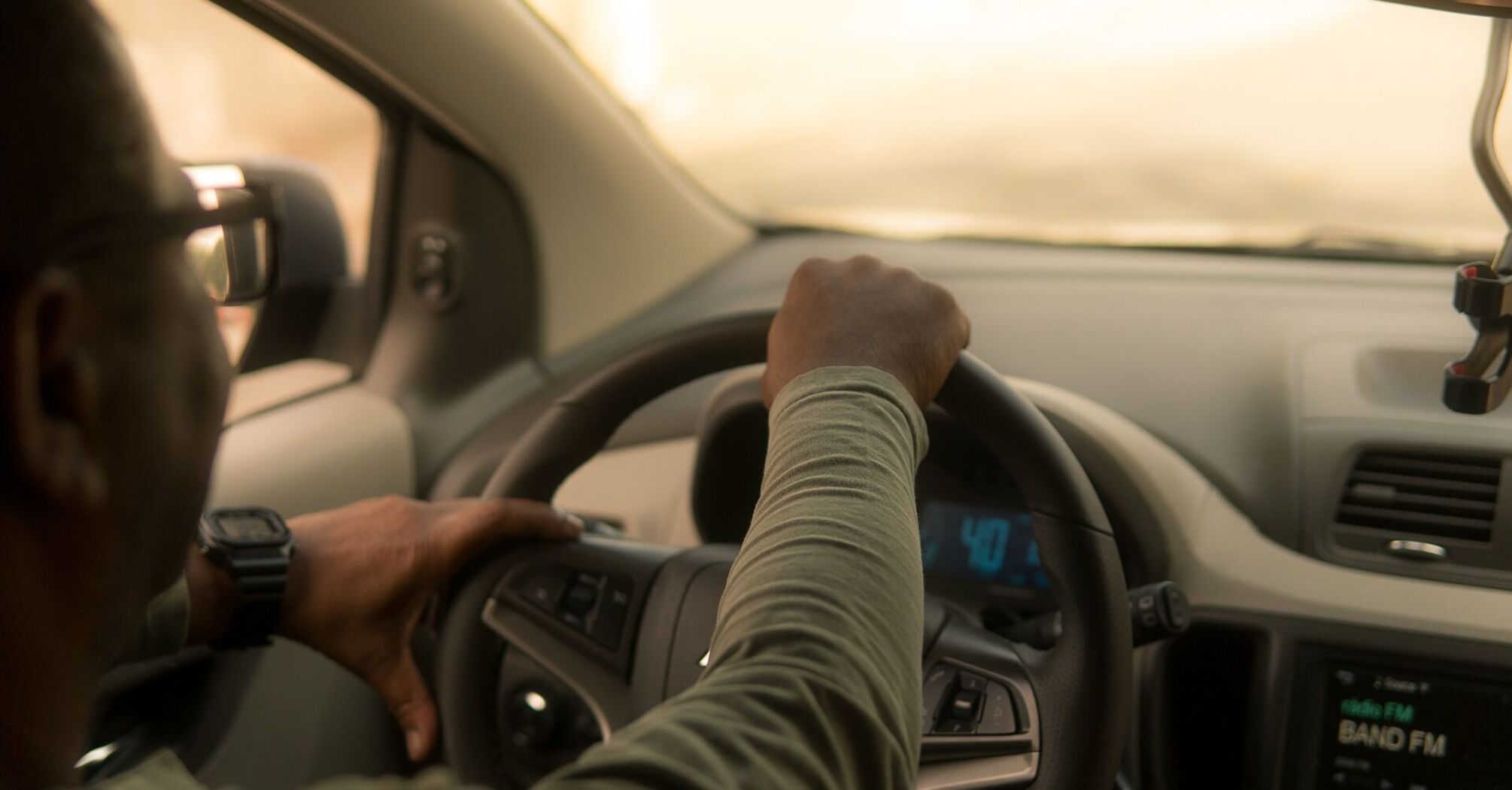 A taxi driver navigating a car through city streets