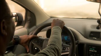 A taxi driver navigating a car through city streets