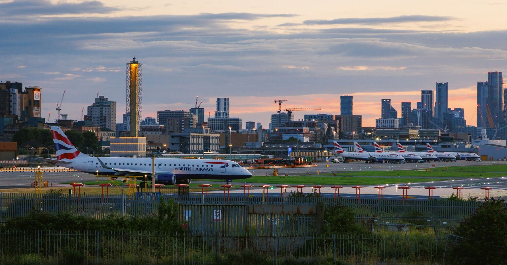 View of London City Airport at sunset with British Airways planes on the runway