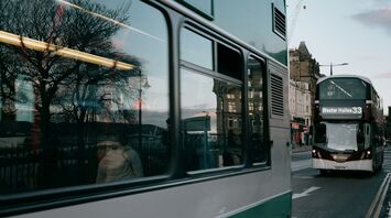 A Lothian double-decker bus on the number 33 route driving through a street in Edinburgh during early evening