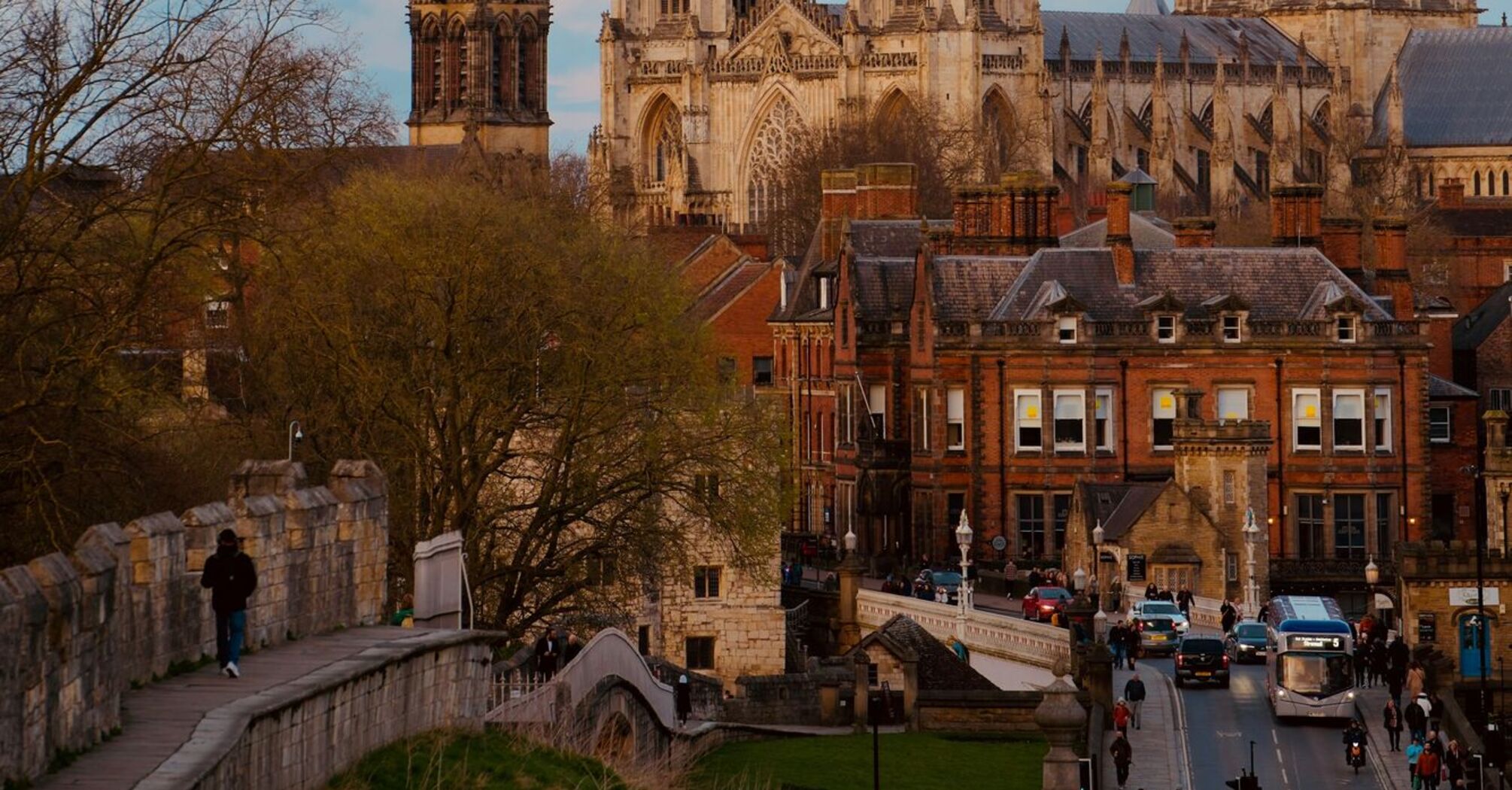 View of York Minster at dusk, with surrounding historic buildings and the city wall