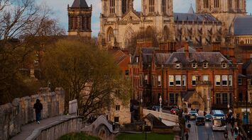View of York Minster at dusk, with surrounding historic buildings and the city wall
