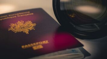 French passport next to a camera lens