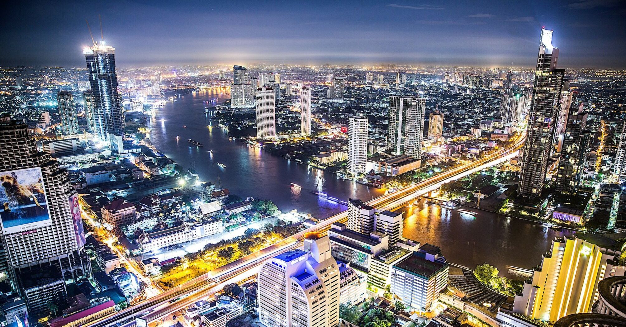 Night view of Bangkok cityscape with illuminated skyscrapers and Chao Phraya River