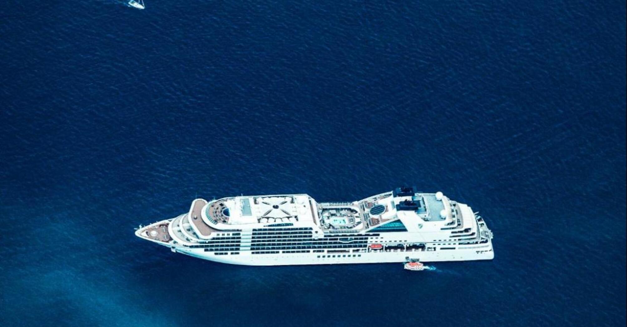 Aerial view of a large cruise ship sailing through deep blue ocean waters