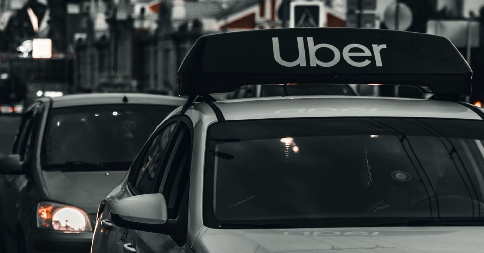 A Hyundai car with an Uber sign on the roof in city traffic