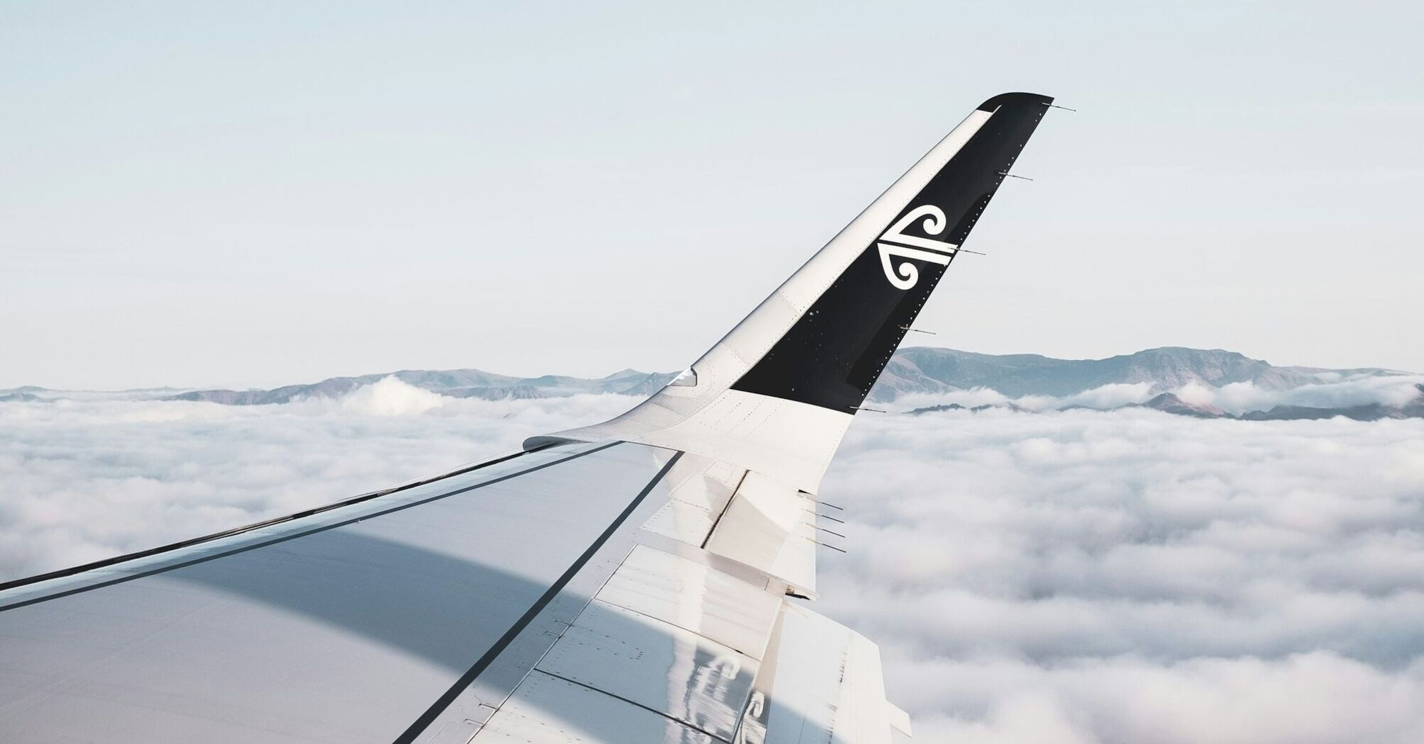 Air New Zealand airplane wing over clouds