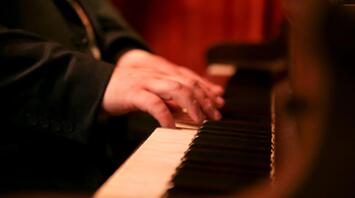 Close-up of a pianist's hands playing the keys of a grand piano