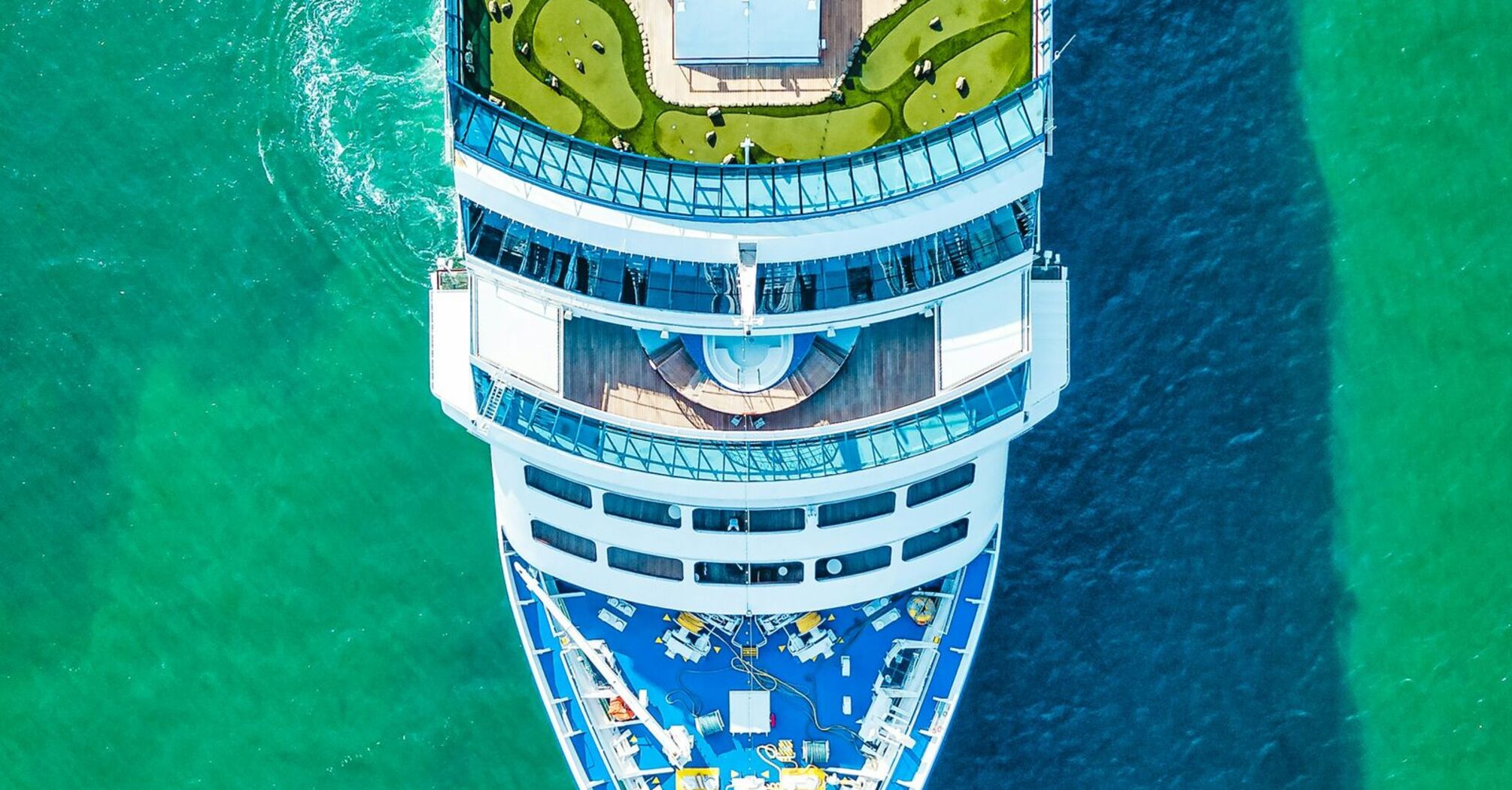 Aerial view of a cruise ship sailing in clear turquoise waters