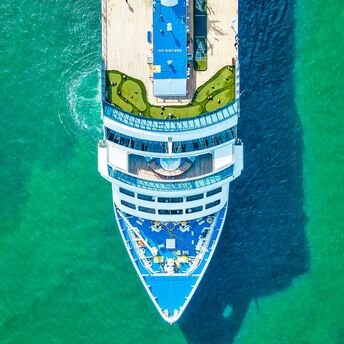 Aerial view of a cruise ship sailing in clear turquoise waters