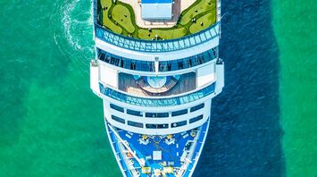 Aerial view of a cruise ship sailing in clear turquoise waters