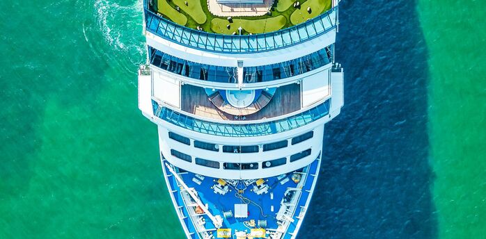 Aerial view of a cruise ship sailing in clear turquoise waters