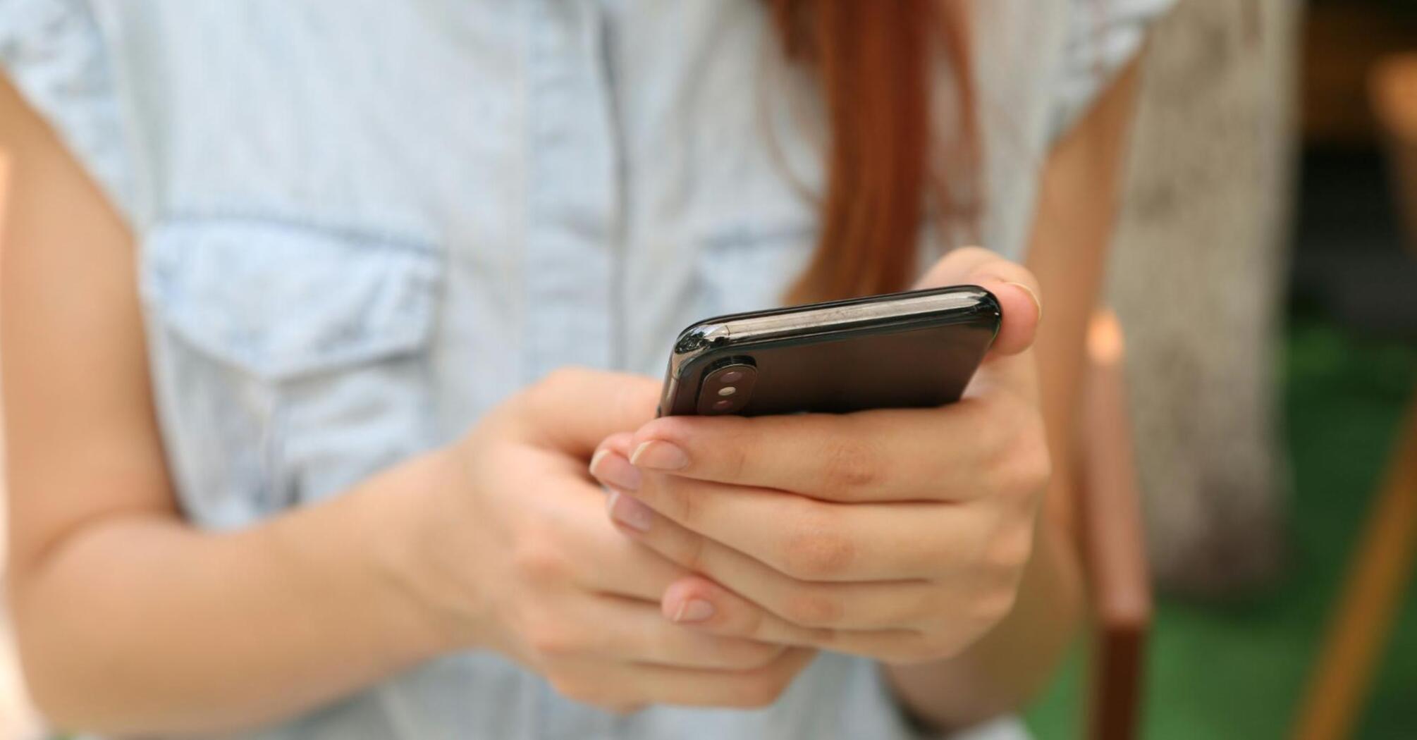 Person holding a smartphone, focused on using the screen