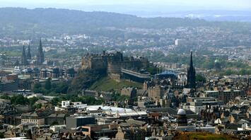 A panoramic view of Edinburgh, showcasing its historic architecture and surrounding landscape