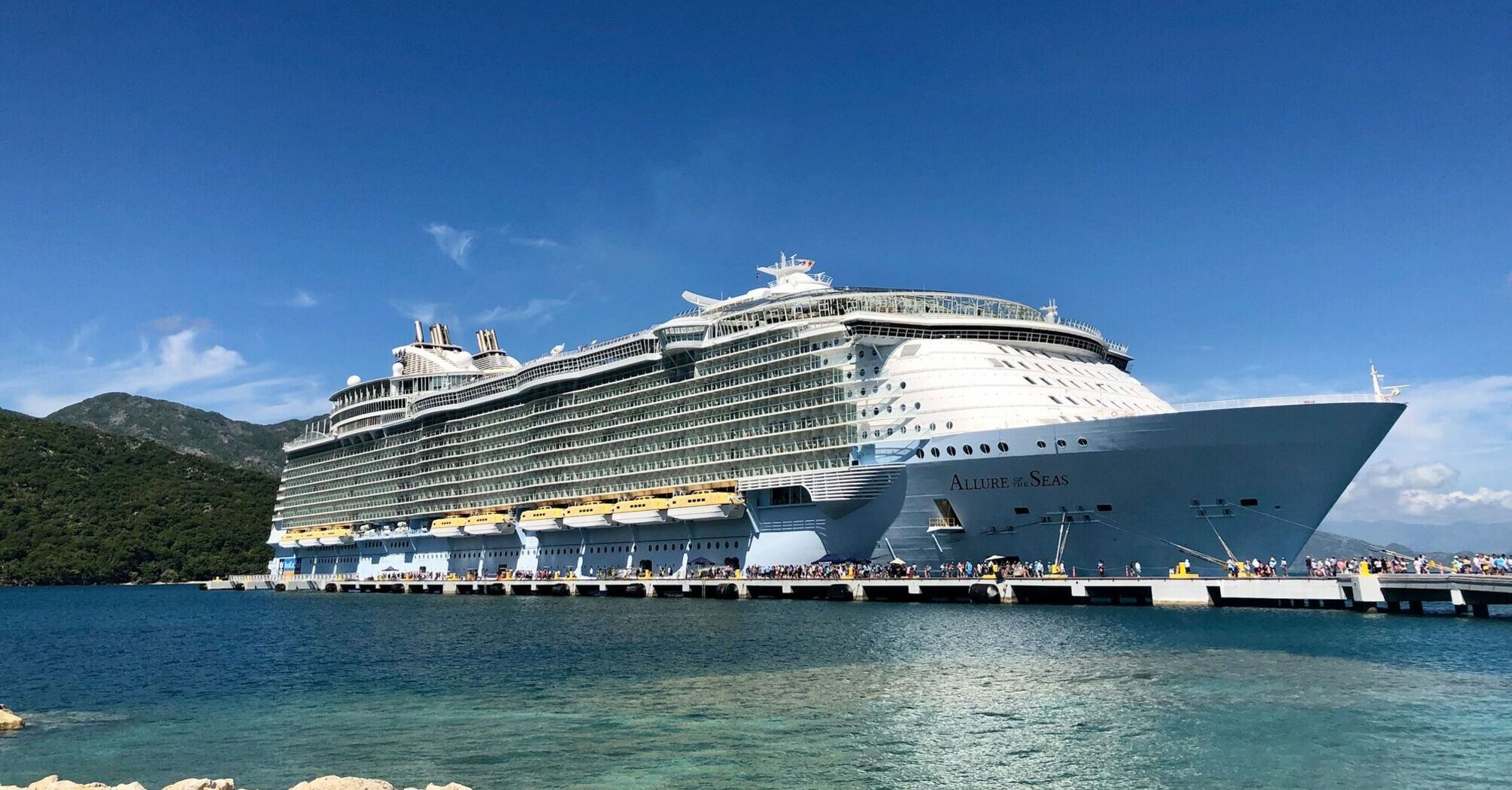 A large cruise ship docked at a scenic port