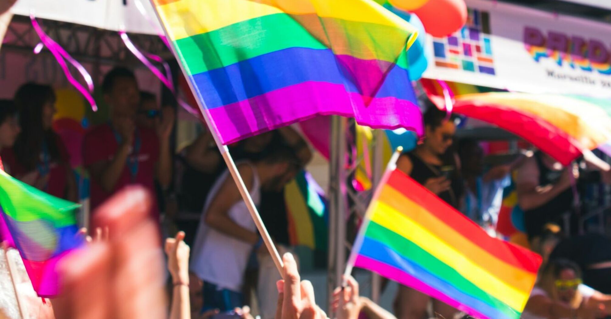 People waving rainbow flags at a pride parade