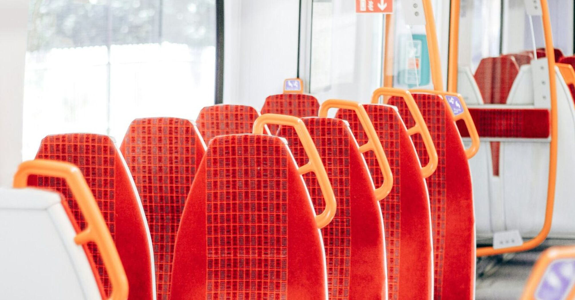 Interior of a SWR train with bright orange and red seats