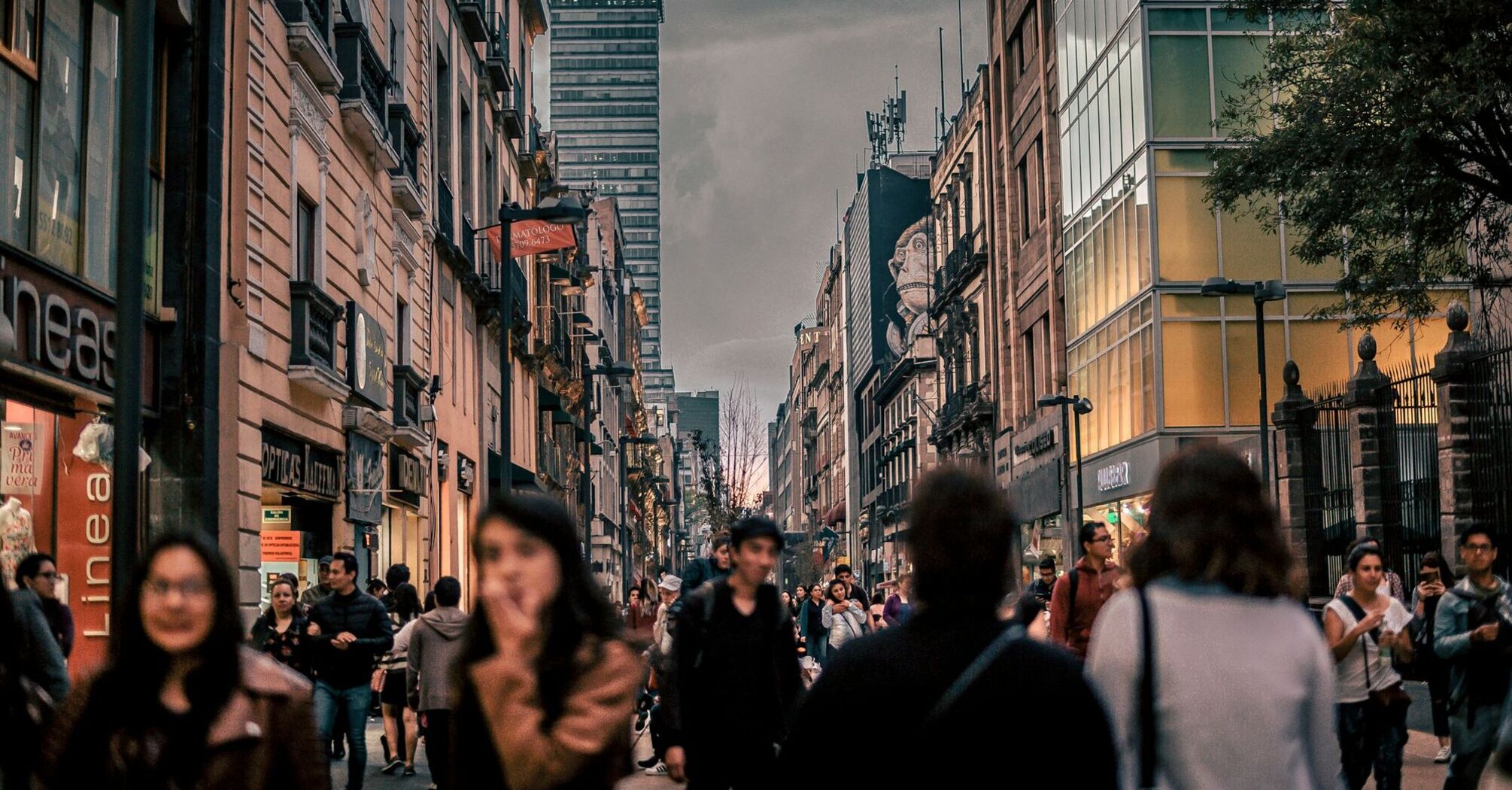 Busy street in Mexico City with tall buildings and people walking