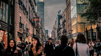 Busy street in Mexico City with tall buildings and people walking