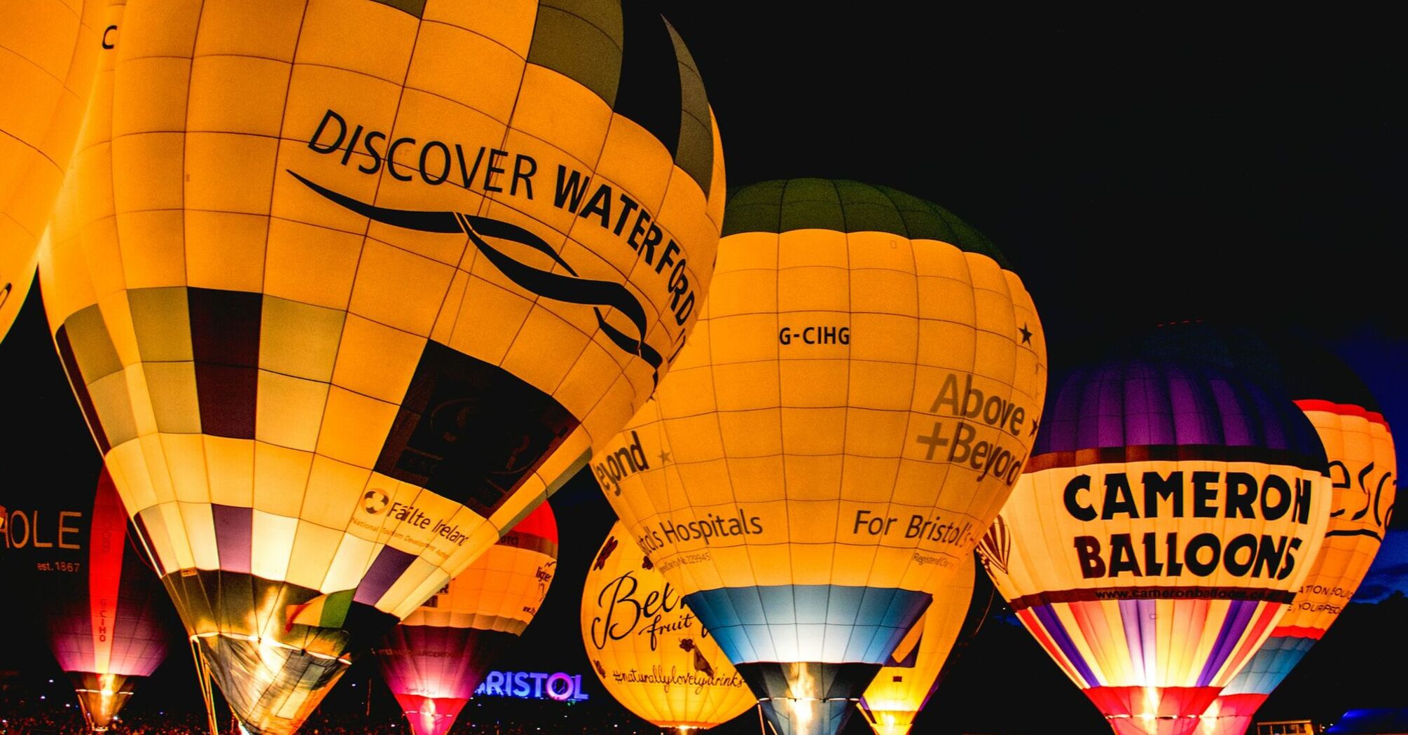 Illuminated hot air balloons glowing at night during the Bristol International Balloon Fiesta