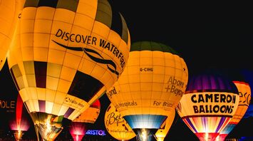 Illuminated hot air balloons glowing at night during the Bristol International Balloon Fiesta