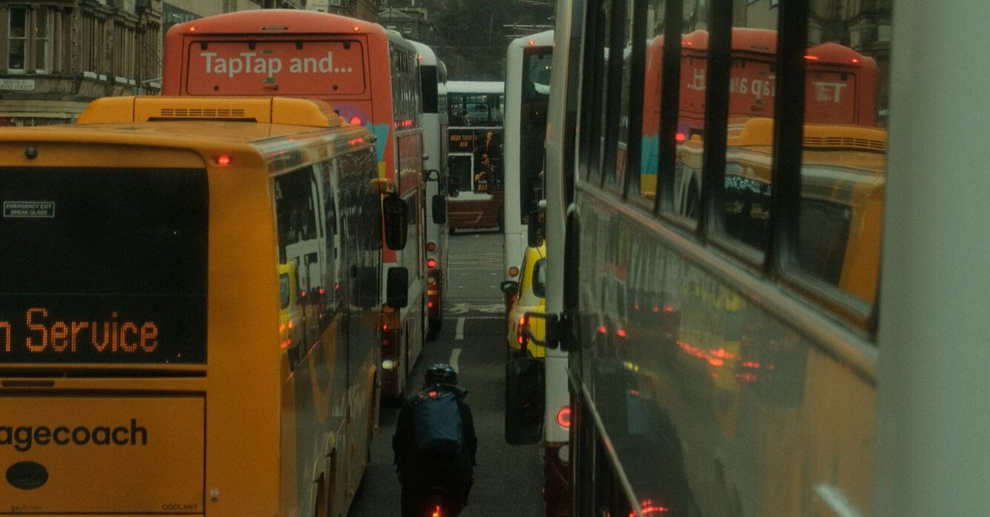 Buses and a cyclist in traffic on a busy street in Edinburgh