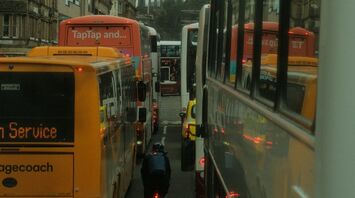 Buses and a cyclist in traffic on a busy street in Edinburgh