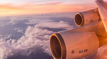 Aerial view of a airplane engine flying above clouds during sunset