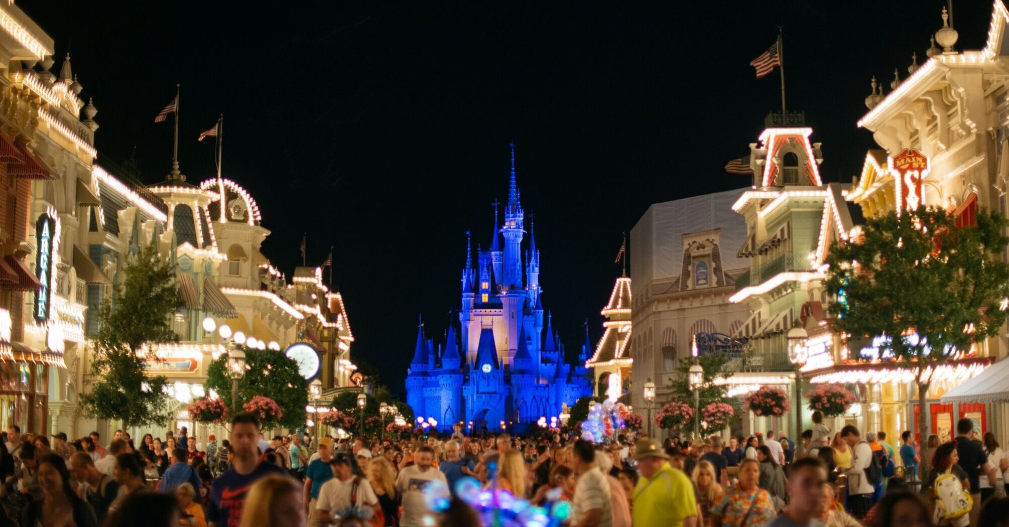 Nighttime view of Main Street in Magic Kingdom with Cinderella Castle illuminated in the background