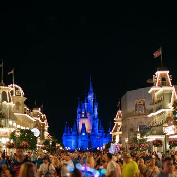 Nighttime view of Main Street in Magic Kingdom with Cinderella Castle illuminated in the background