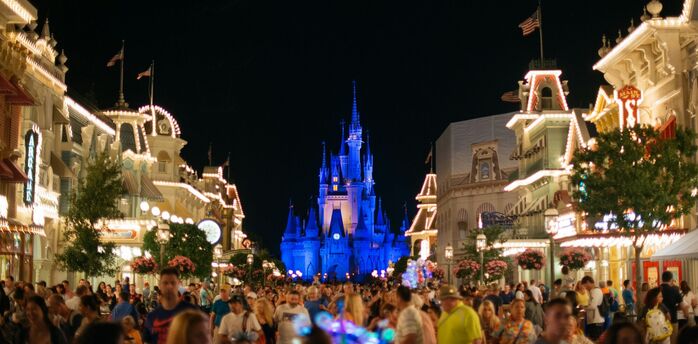 Nighttime view of Main Street in Magic Kingdom with Cinderella Castle illuminated in the background