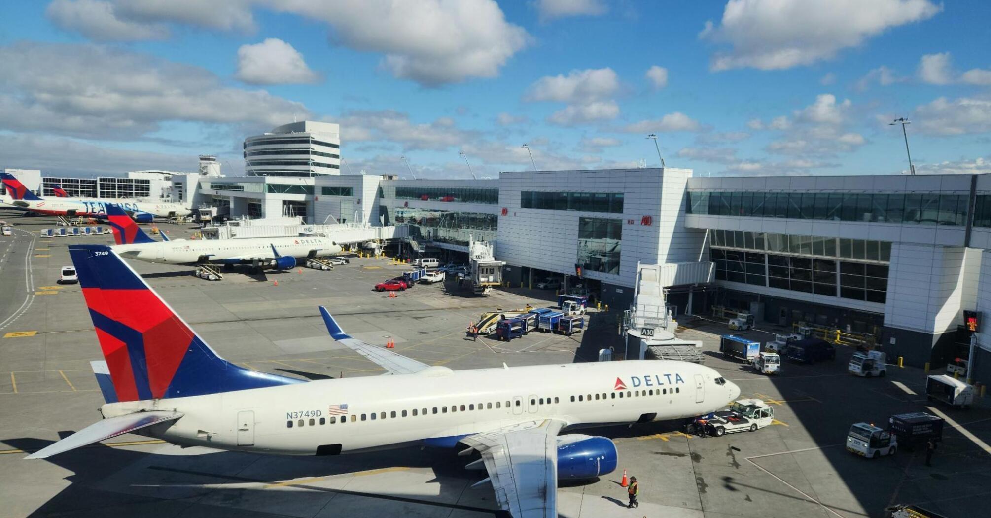 Seattle-Tacoma Airport with Delta Airlines planes on the tarmac under a blue sky before travel begins