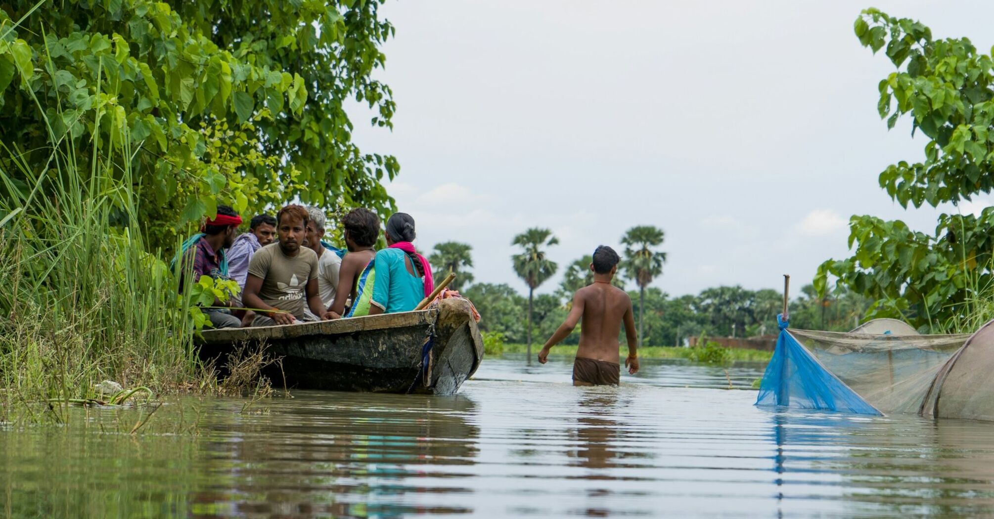 People navigating floodwaters in a boat