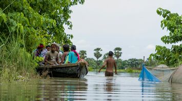 People navigating floodwaters in a boat