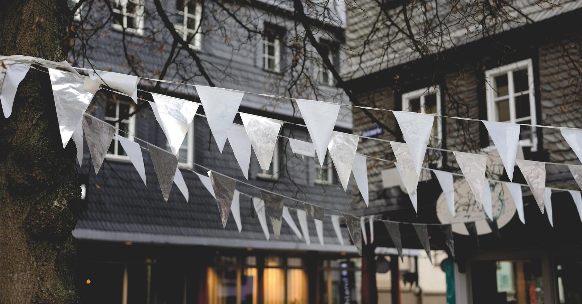 White and silver flags hanging in front of a building