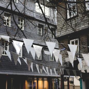 White and silver flags hanging in front of a building