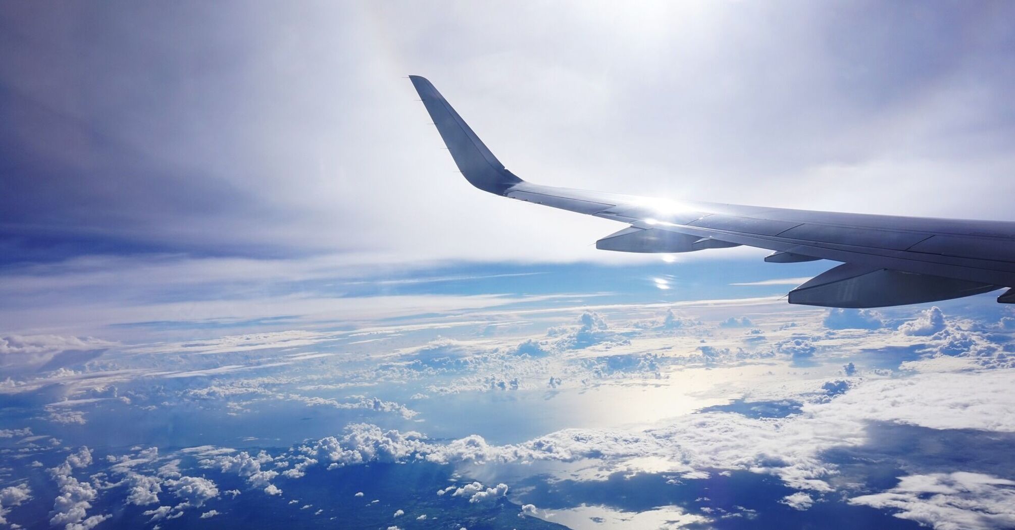 View from airplane window showing clouds and ocean