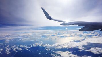 View from airplane window showing clouds and ocean