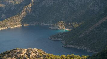 A tiny secluded beach with turquoise waters illuminated by the early morning sun, Aegean ocean, Fethiye, Turkey