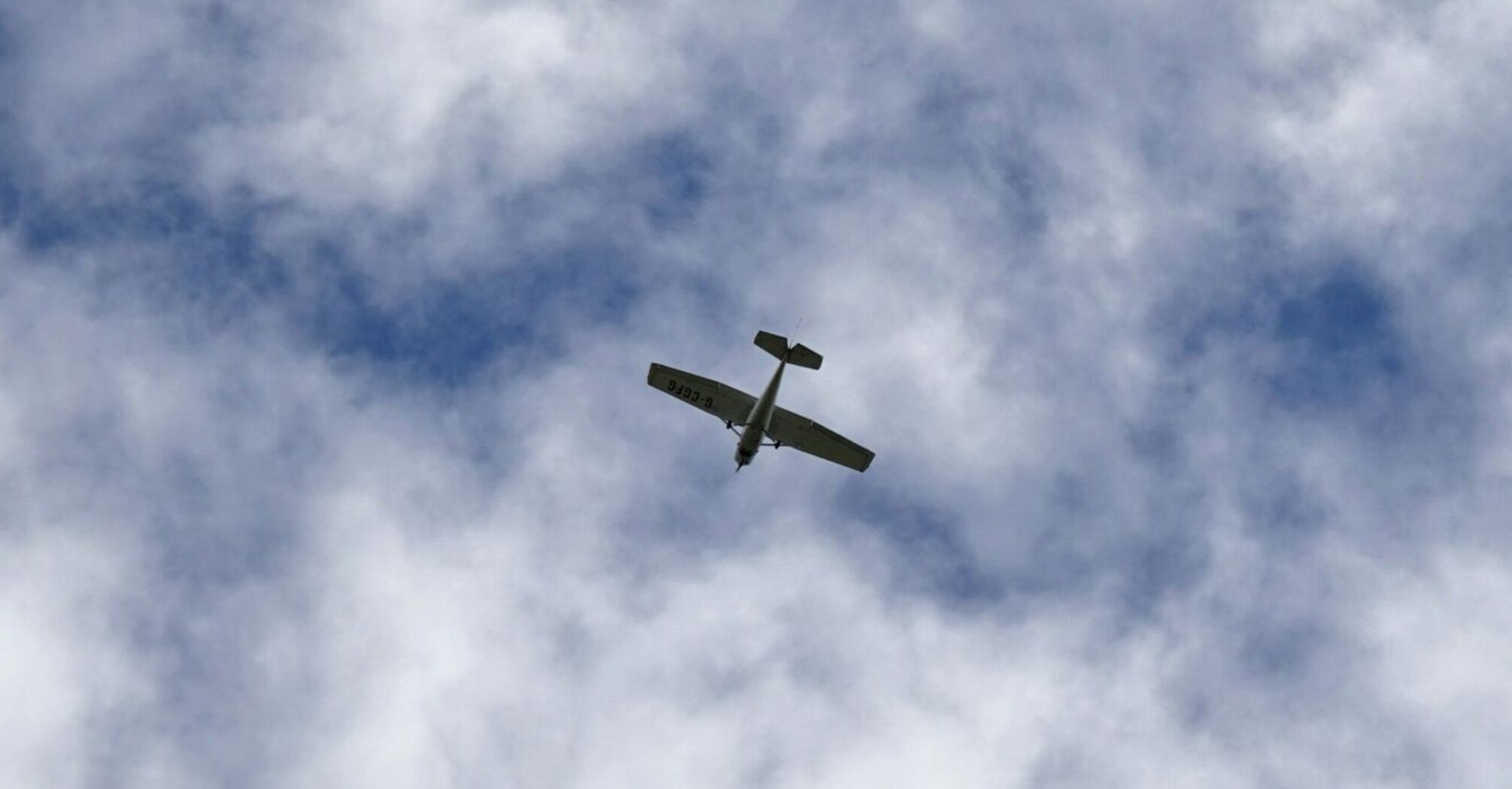 Small plane flying in cloudy sky