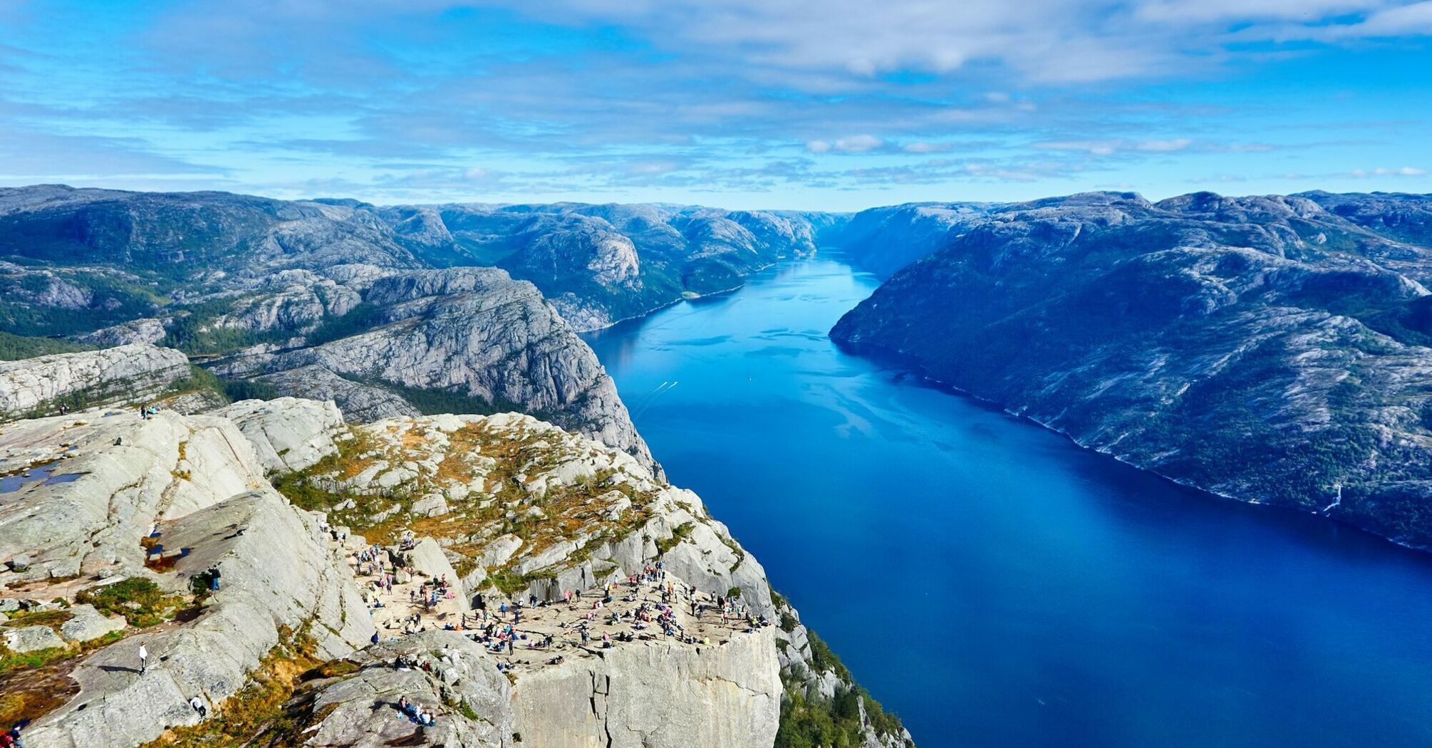 Tourists on a cliff overlooking a fjord in Norway