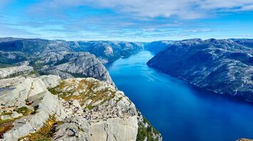 Tourists on a cliff overlooking a fjord in Norway