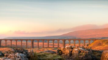 Sunset over viaduct with rolling hills in the background